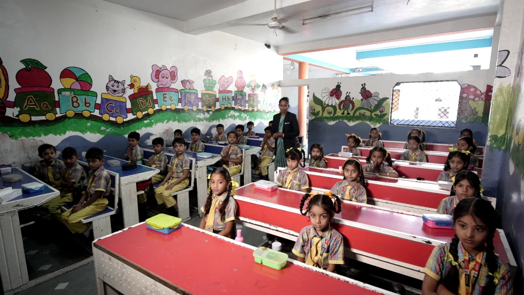 Students studying wit a teacher in a classroom in City public school